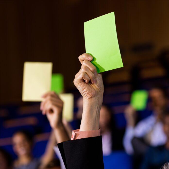 Business executives show their approval by raising hands